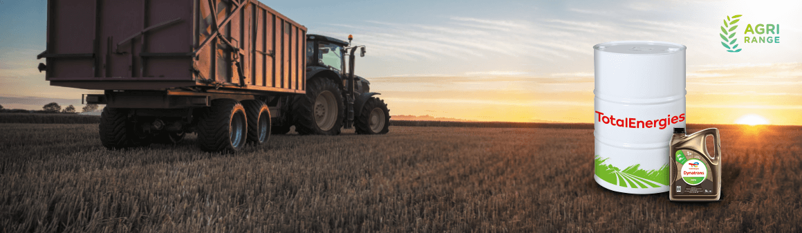 Egy pótkocsis traktor látképe a szántóföldön az Agri olajokkal teli kannákkal és hordókkal kiegészítve