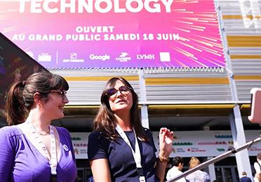 A TotalEnergies két képviselője egy csarnok előtt áll, ahol a Vivatech 2022 kiállítás zajlik