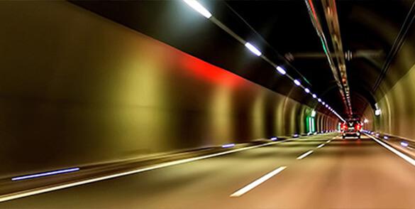 Egy kivilágított alagút a benne haladó autóval